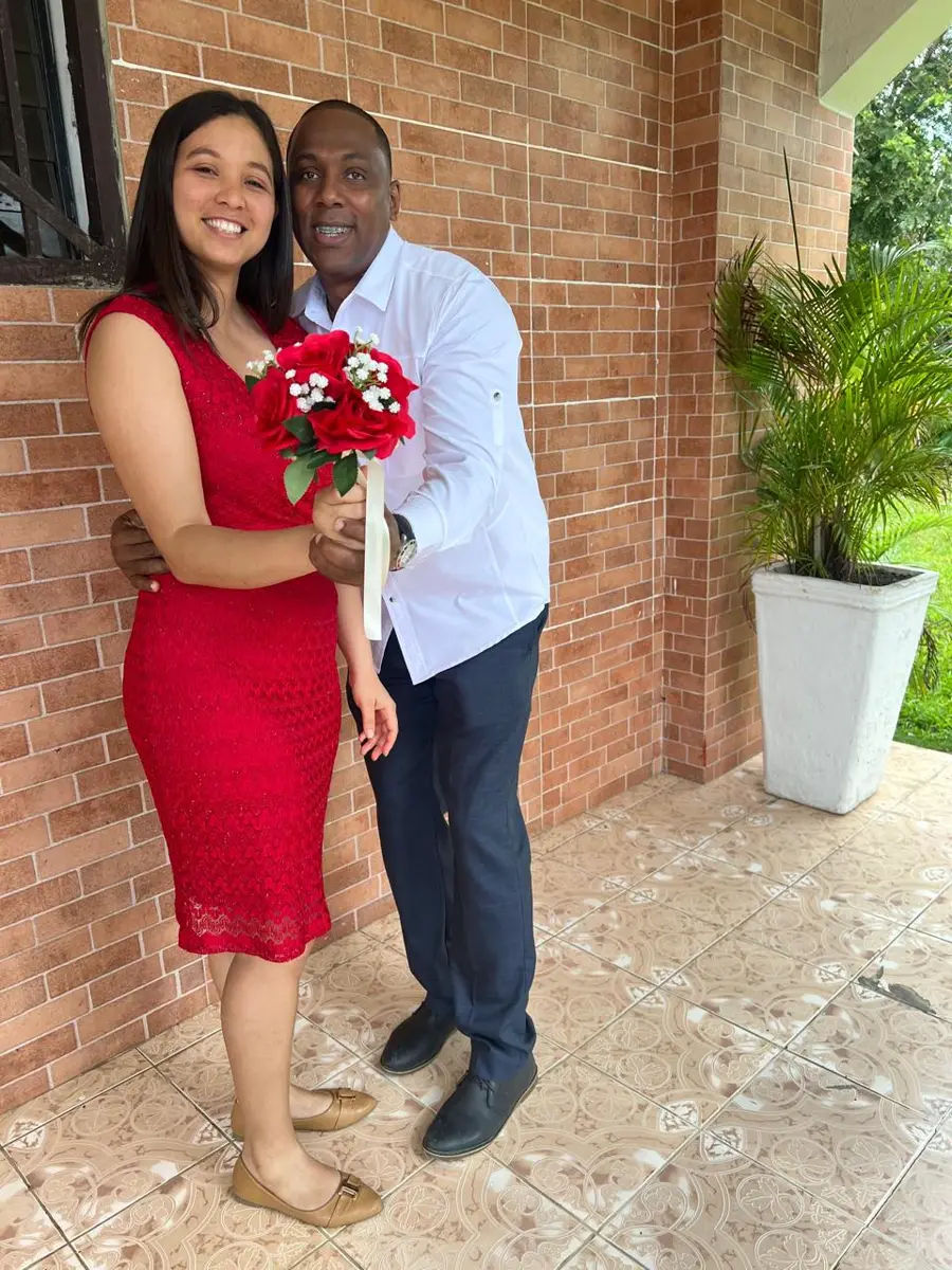 Carlos y Malenny sonrientes con un ramo de rosas